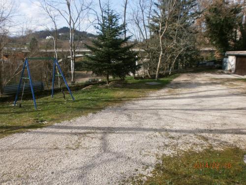 an empty road with a swing set in the grass at B&B Pippinella in Urbania