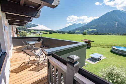a balcony with a view of a lawn and mountains at Gästehaus Dreier in Neukirchen am Großvenediger