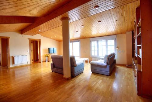a living room with two chairs and a table at Cuencaloft Casa Rural Lagunas de Arcas in Arcas