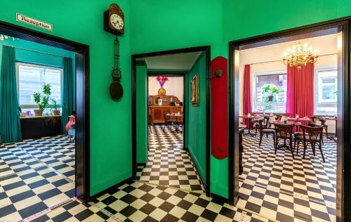 a restaurant with green walls and tables and a clock at SmartHotel Mystique Self check-in in Bad Homburg vor der Höhe