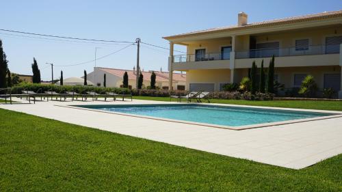 a swimming pool in a yard next to a building at Apartamento 7 Mares com Suite in Sagres