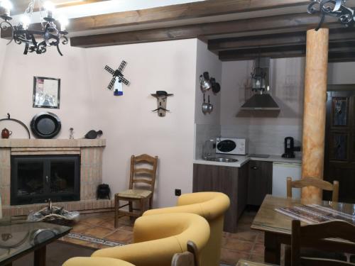 a living room with a fireplace and a table and chairs at EL LABRIEGO, Casa rural in Fuente el Fresno