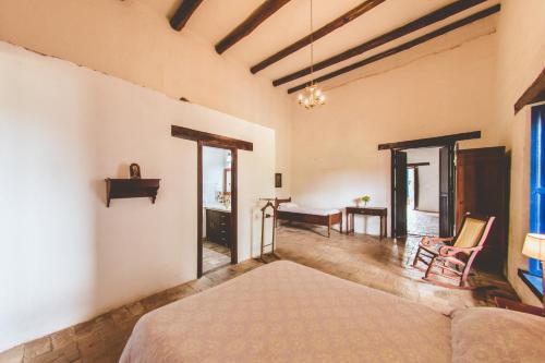 a bedroom with a bed and a desk in a room at Hacienda Pisoje in Popayan
