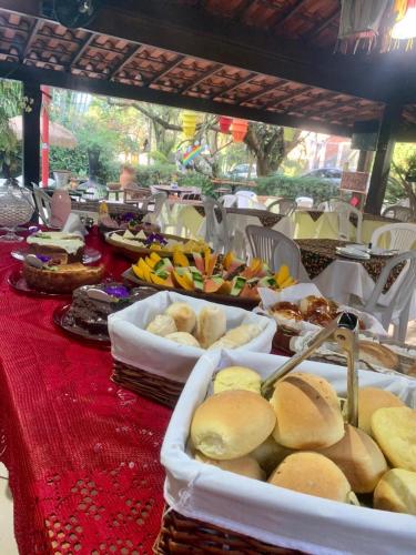 a table topped with trays of food on a table at Pousada Pedras Brancas in Niterói