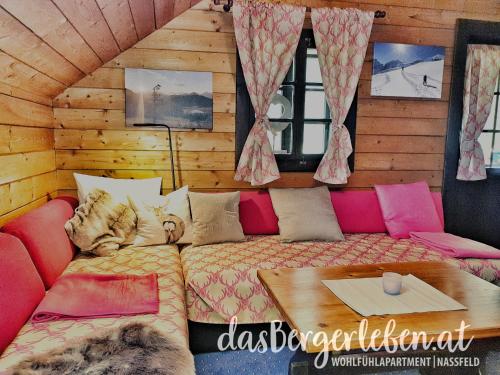 a living room with a couch and a table at das Bergerleben in Sonnenalpe Nassfeld
