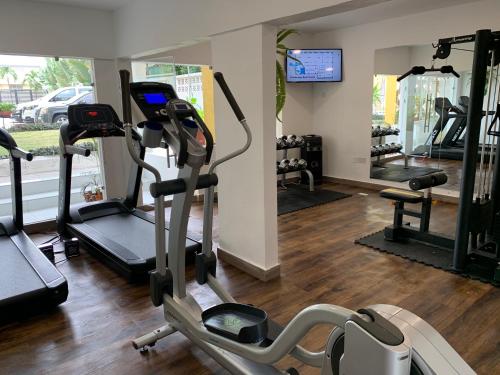 a gym with tread machines and a tv in a room at The Cabin Hotel in Accra