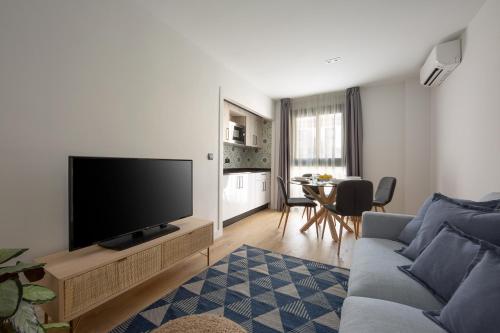a living room with a couch and a television at Flipco Málaga in Málaga