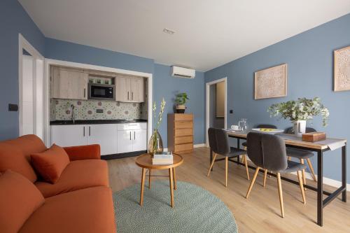 a living room and kitchen with a couch and a table at Flipco Málaga in Málaga