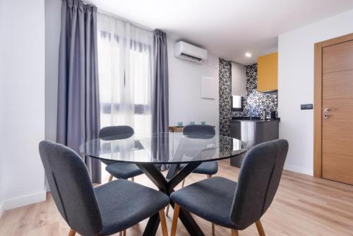a dining room with a glass table and chairs at Flipco Málaga in Málaga