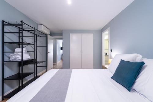 a bedroom with a white bed and a black shelf at Flipco Málaga in Málaga