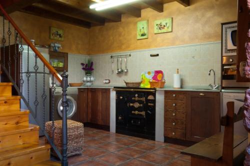 una cocina con fogones y fregadero y una escalera en Casa Lolo de Villaviciosa en Camoca