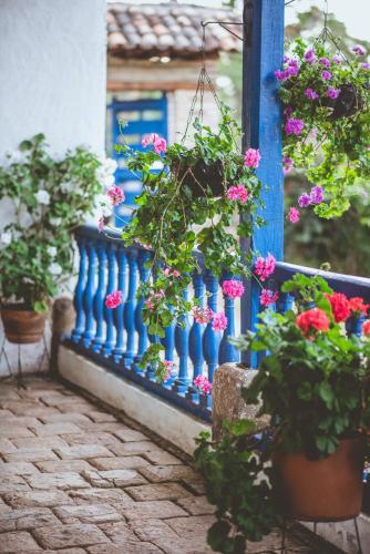 a blue fence with flowers on a balcony at Hacienda Pisoje in Popayan