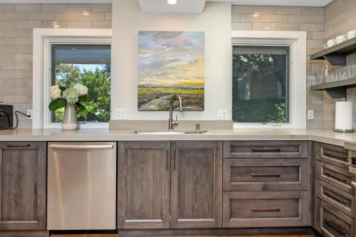 eine Küche mit einem Waschbecken und zwei Fenstern in der Unterkunft The Oxbow House - Designer 3BD/2BA Home in Napa