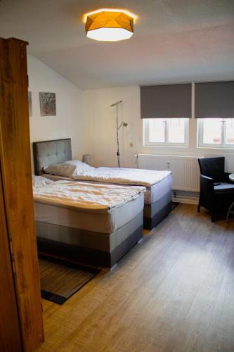 a bedroom with two beds and a desk with a chair at Krugs Haus Ferienwohnungen Ebersburg in Ebersburg
