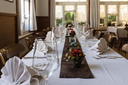 a long table with wine glasses and flowers on it at Gasthof Hirschen in Oey