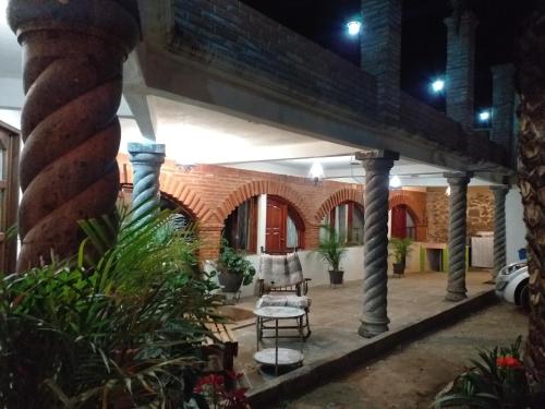 een patio 's nachts met een stoel en een tafel bij Hotel Huasca Terrazza in Huasca de Ocampo
