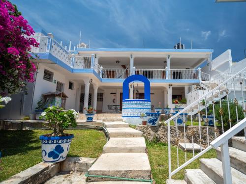 a large white house with blue and white stairs at Hotel Casa Poblana in Bacalar