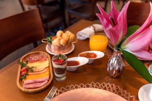 a table topped with plates of food and drinks at Cullinan Hplus Premium in Brasília