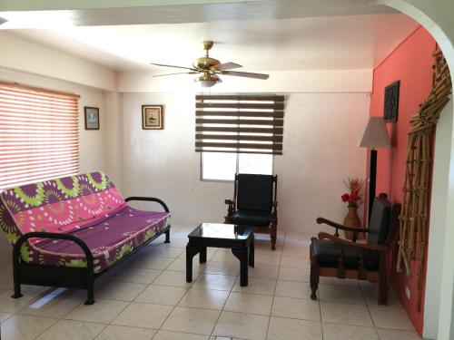 ein Wohnzimmer mit einem Sofa und 2 Stühlen in der Unterkunft Betty's Beach Condominium in Playas