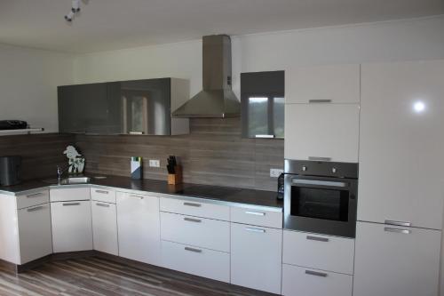 a kitchen with white cabinets and a stove top oven at Appartement Winteraugut in Werfen