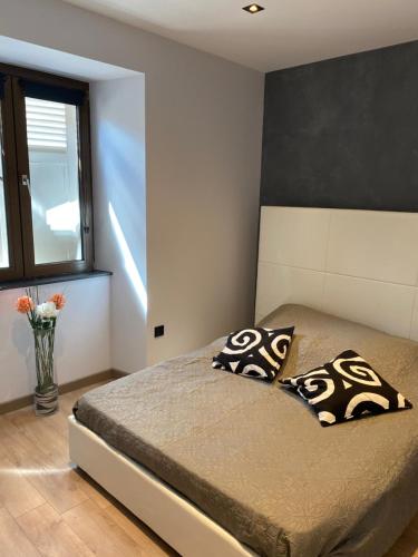 a bedroom with a bed with two pillows and a window at ** Appartement neuf hyper centre ville à Haguenau in Haguenau