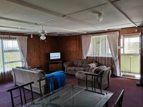 a living room with two couches and a tv at Kayser's Sea Breeze in East London