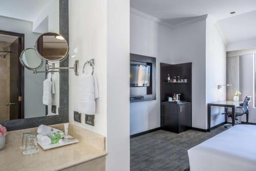 a hotel room with a sink and a mirror at NH Collection Quito Royal in Quito