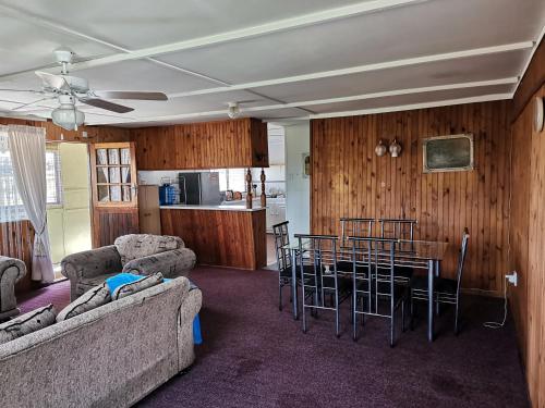 a living room with a couch and a table and chairs at Kayser's Sea Breeze in East London