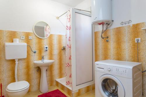 a bathroom with a washing machine and a toilet at Holiday Home Antonija in Stari Grad