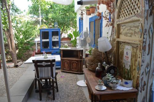 a patio with a table and chairs and a stove at Cunda Adali Pansiyon in Ayvalık