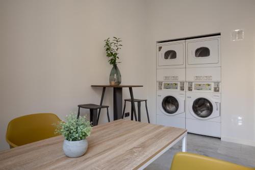 a dining room with a table and washing machines at Flipco Málaga in Málaga