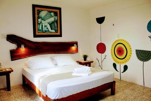 a bedroom with a bed with a wooden headboard at Hostal & Suites Pata de Perro in Bacalar