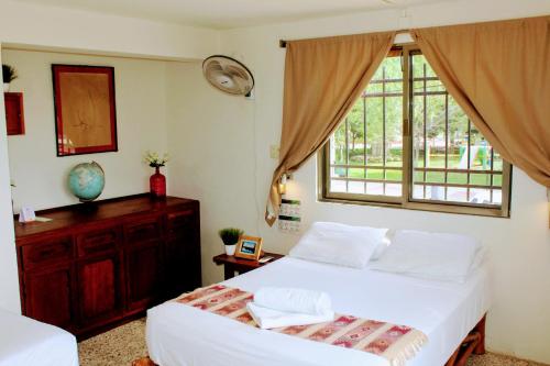 a bedroom with a large bed and a window at Hostal & Suites Pata de Perro in Bacalar