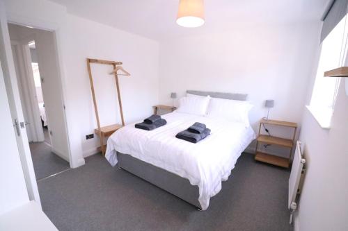 a bedroom with a large white bed with two towels on it at Amaya Three - Newly Renovated - Sleeps 6 - Grantham in Grantham
