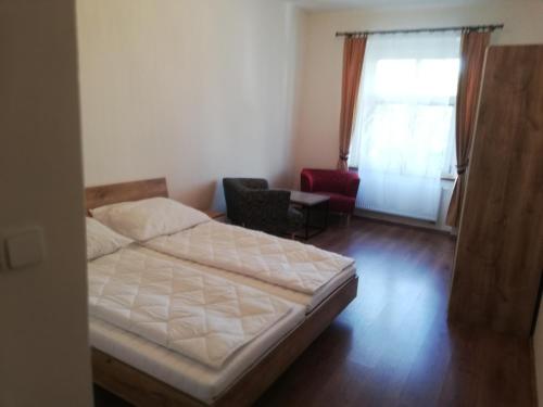 1 dormitorio con 1 cama, 1 silla y 1 ventana en Apartment 70m2, en Karlovy Vary