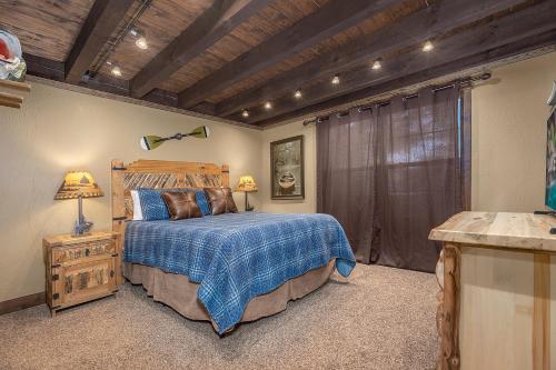a bedroom with a bed and a wooden ceiling at Mountain Creek Cabin - Luxury Lakefront Home - Hot Tub- Pool Table - Movie Theater in Lampe