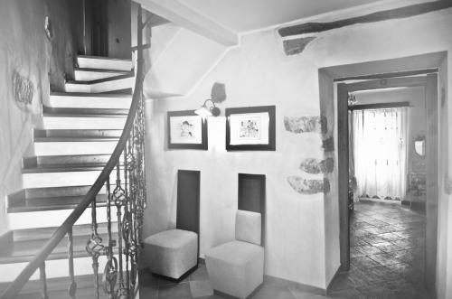 a hallway with a staircase with two pictures on the wall at Casa De Ajala - B&B de Charme in Antica Dimora totalmente ristrutturata e dotata di tutti i confort Bagni privati Spazio living Patio esterno Ambienti climatizzati Degustazioni prodotti locali in Làconi