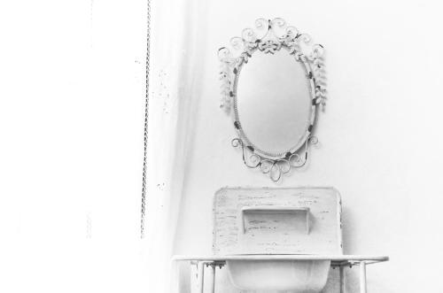 a bathroom with a mirror and a sink at Casa De Ajala - B&B de Charme in Antica Dimora totalmente ristrutturata e dotata di tutti i confort Bagni privati Spazio living Patio esterno Ambienti climatizzati Degustazioni prodotti locali in Làconi
