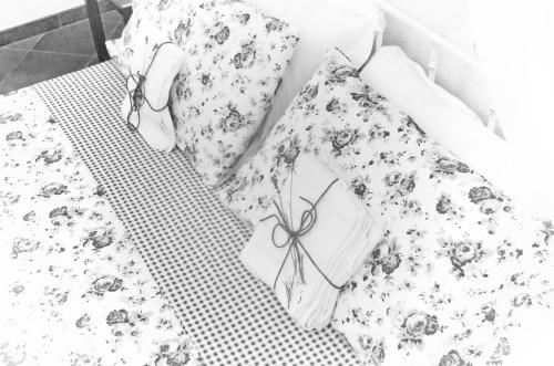 a woman laying on a bed with a floral bedspread at Casa De Ajala - B&B de Charme in Antica Dimora totalmente ristrutturata e dotata di tutti i confort Bagni privati Spazio living Patio esterno Ambienti climatizzati Degustazioni prodotti locali in Làconi