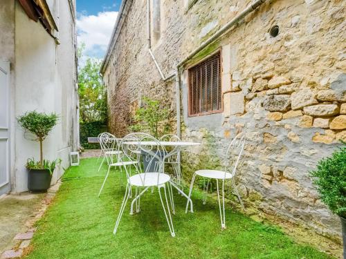 une table et des chaises sur l'herbe devant un bâtiment dans l'établissement Apartment Isigny-sur-Mer near Sea, à Isigny-sur-Mer