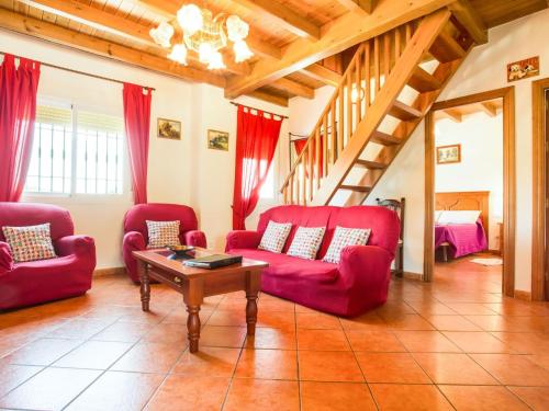 GuaroにあるBelvilla by OYO La Vistaのリビングルーム(赤い椅子、テーブル付)