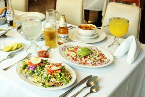 a table with plates of food and drinks on it at Hotel Fray Junipero Serra in Tepic
