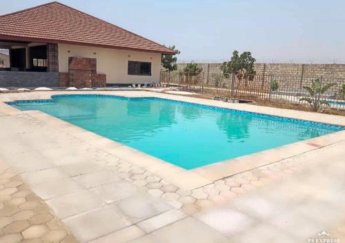 a swimming pool with blue water in front of a house at Gorgeous 3 bedroom home in the heart of Lusaka in Lusaka