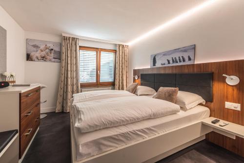 une chambre avec un grand lit et un lavabo dans l'établissement Central & Elegant Apartments,partially with Fireplace, by Zermatt Rental, à Zermatt