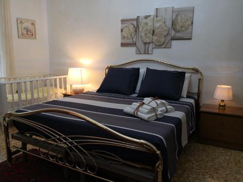 a bedroom with a large bed with blue and white sheets at "Lemon Tree House" with garage for MTB in Orco Feglino