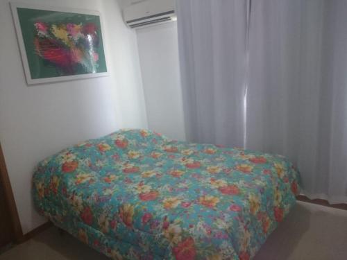 イタブーナにあるSolaris Residencial Clube - Ilhéusのベッドルーム1室(カラフルな毛布付きのベッド1台付)