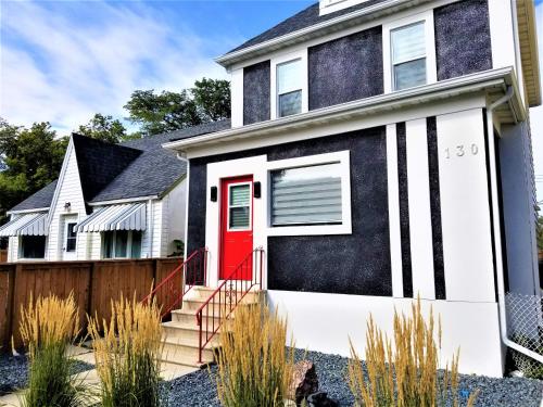 a black and white house with a red door at Hawaii-Peg in Winnipeg