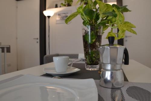 uma mesa com uma cafeteira e uma chávena em Belle Donne Apartment em Benevento