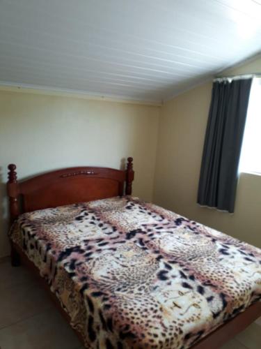 Dormitorio con cama con manta de leopardo en Residencial Caxias, en Bombinhas