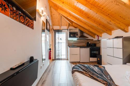 a small room with a bed and a kitchen at Casa das Rendas by CosyCasa Praia Peniche in Peniche